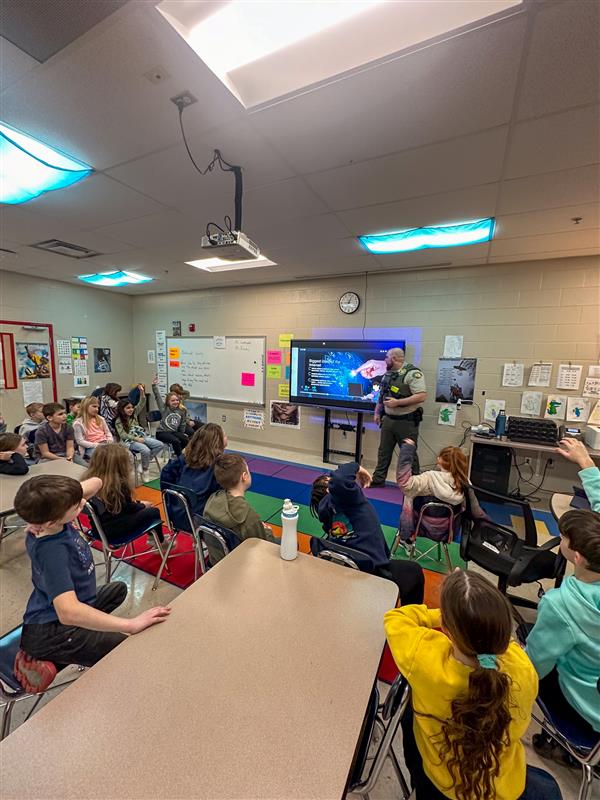 police officer talking to class of students